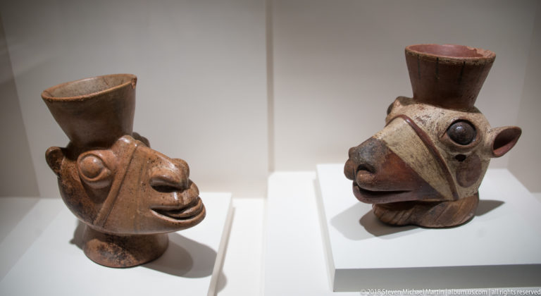 Two Mochica ceramic vessels with rounded bodies, tall flared necks, and modeled animal-like heads.