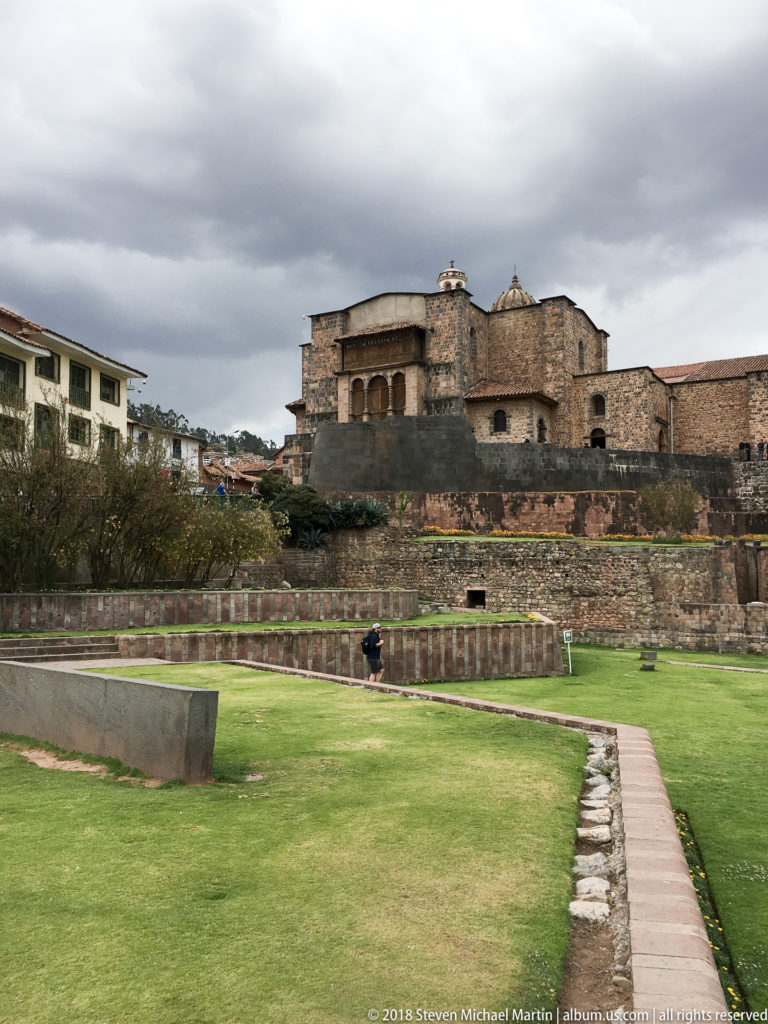 Terraced green grounds and stone walls beneath the Church and Convent of Santo Domingo at Qorikancha.