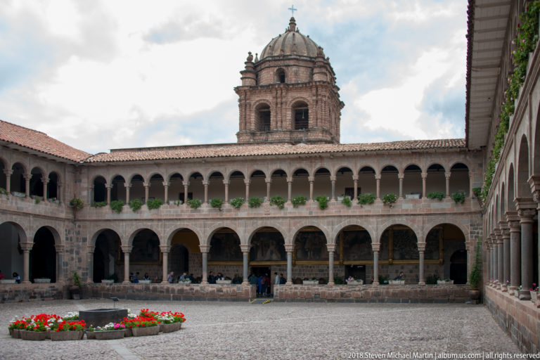 Oblique view across the Santo Domingo cloister courtyard toward the domed bell tower and receding arcades.