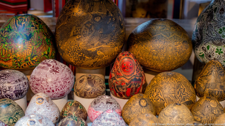 Colorfully painted and incised gourds of different sizes crowded together in a Cusco shop display.