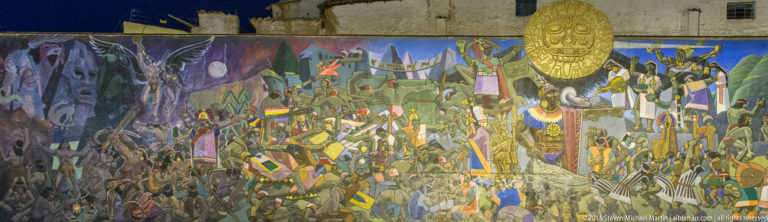 Long colorful historical mural crowded with figures and banners, dominated at right by a large golden Inca-style sun face.