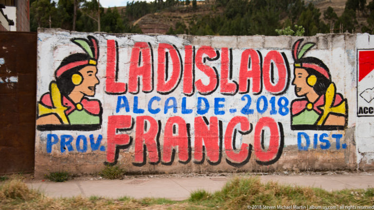 Colorful wall mural reading Ladislao, Alcalde 2018, and Franco, flanked by two stylized profile figures.