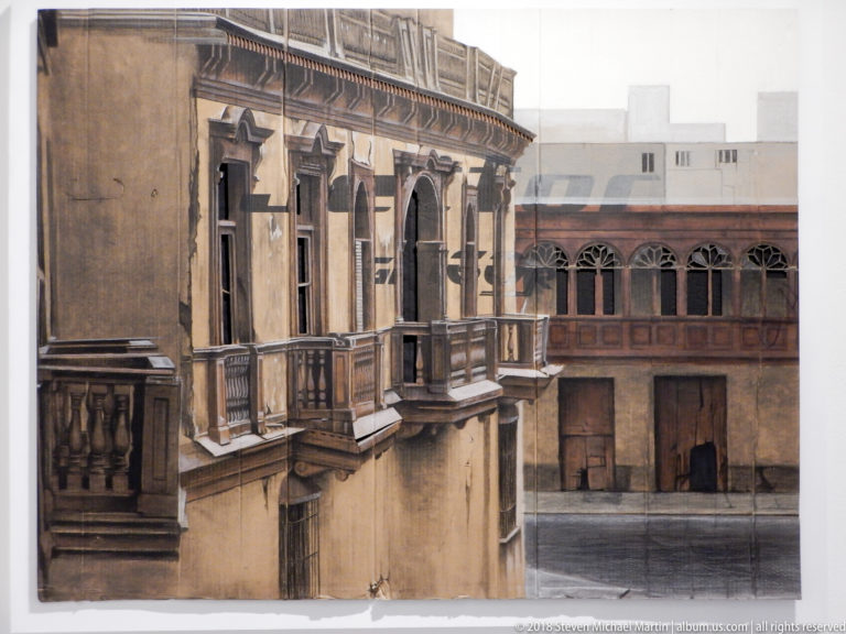 Framed artwork showing weathered historic balconies and arched windows around a courtyard in muted brown tones.
