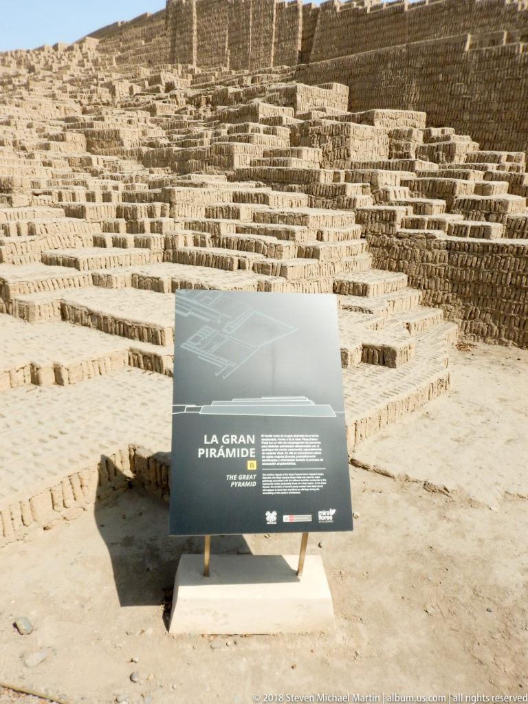 Interpretive sign reading “La Gran Pirámide” in front of the stepped adobe architecture of Huaca Pucllana.