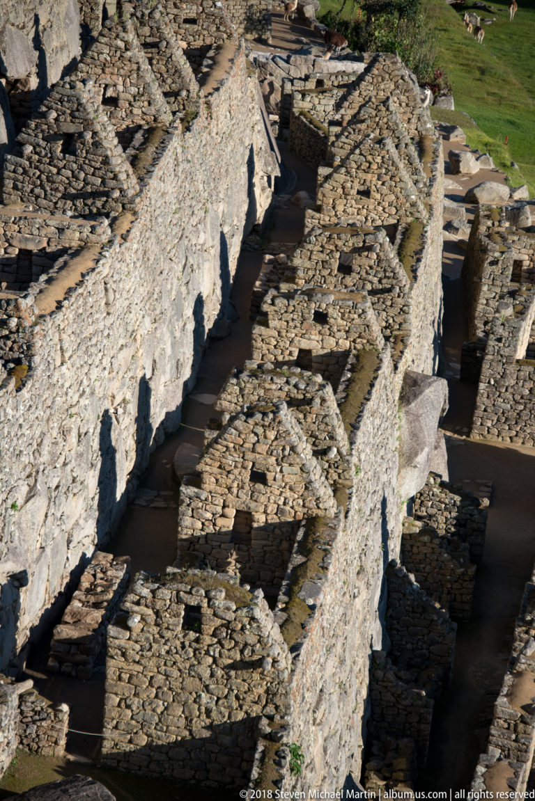Parallel roofless stone chambers and corridors viewed from above at Machu Picchu.