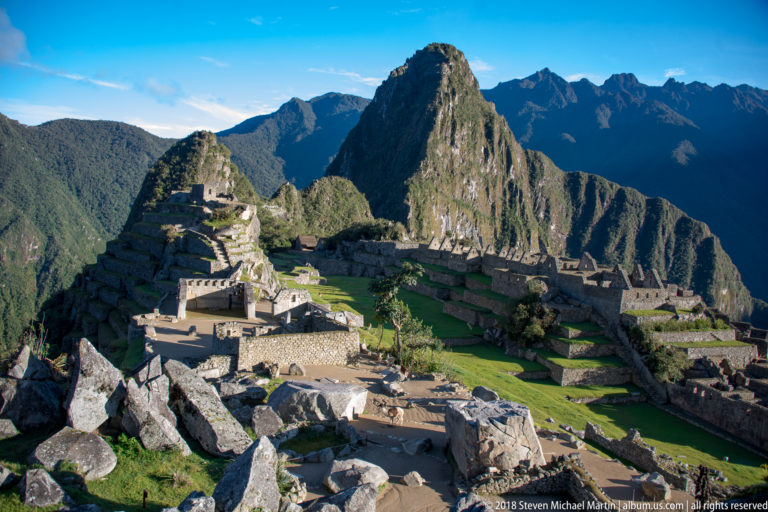 High panoramic view across Machu Picchu’s stone sectors, terraces, boulders, and Huayna Picchu.