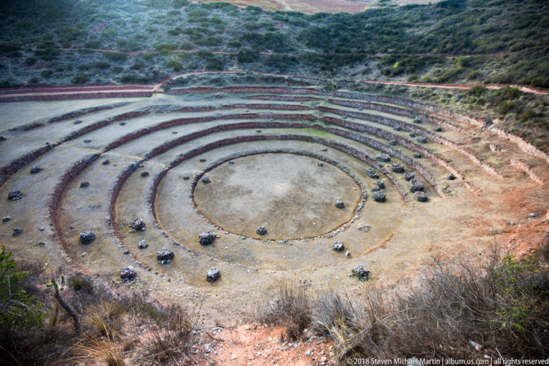 Circular terraces at Moray seen from above with numerous visitors scattered along the rings and central floor.