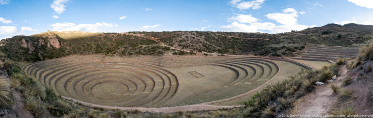 Wide elevated view of Moray's concentric terraced bowl, central rectangular feature, and additional terraces on the right hillside.