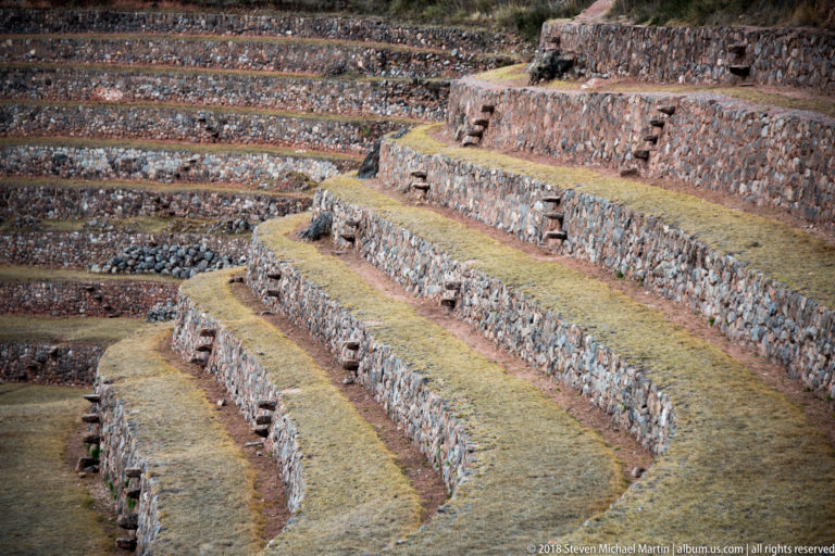 Curving stone retaining walls and grassed terrace benches at Moray, with small projecting stone steps between levels.