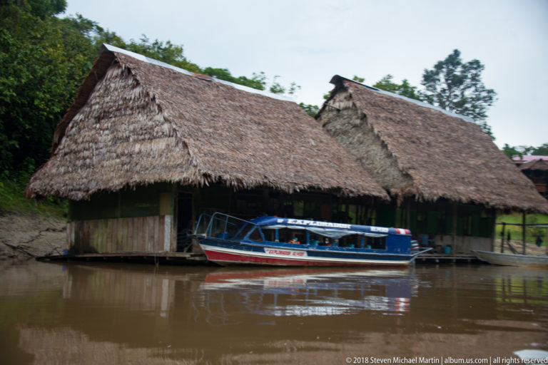 Thatched lodge structure with motorboat at Tuhauyo Lodge.