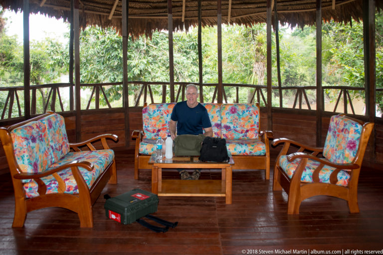 Screened wooden lounge with floral-upholstered seating at Tuhauyo Lodge.