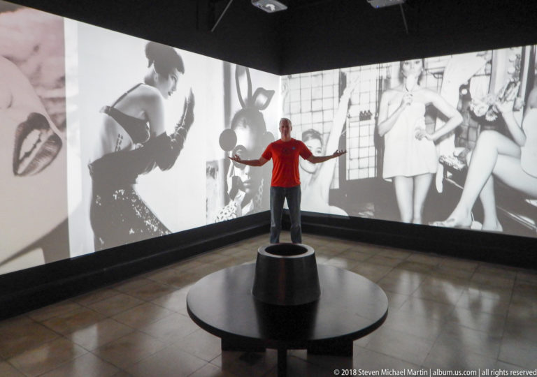 Visitor on a circular platform inside a room wrapped with black-and-white fashion projections.