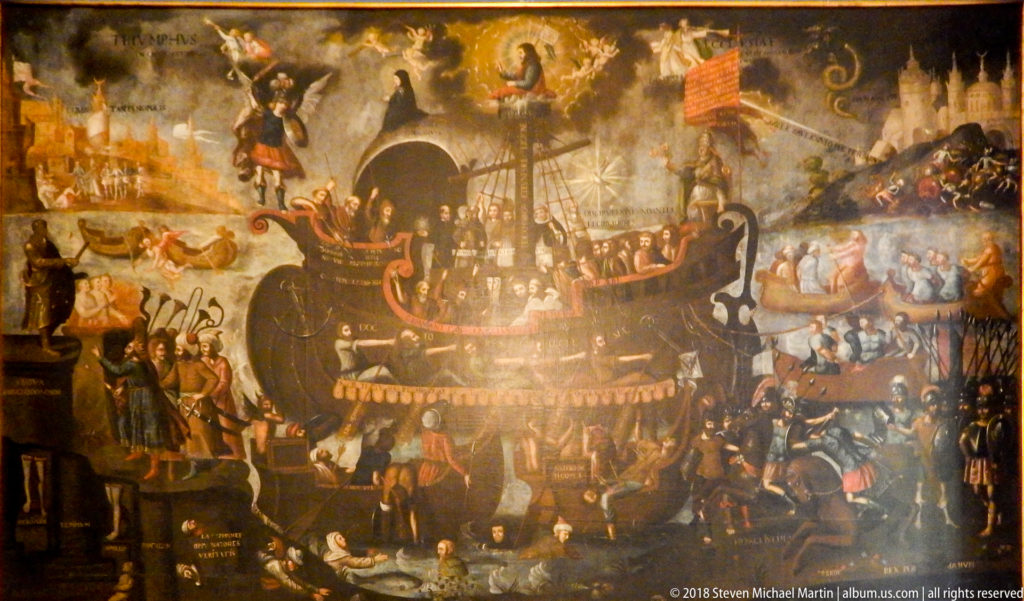 Large dark religious painting crowded with figures around a central ship-like structure, with banners and heavenly scenes above.