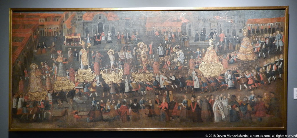 Large framed painting of a crowded colonial procession with clergy, officials, standards, elaborate dress, and urban architecture.