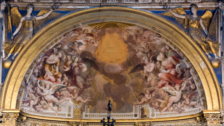 Frescoed figures fill a curved arch above the cathedral sanctuary, beneath a gold central panel.