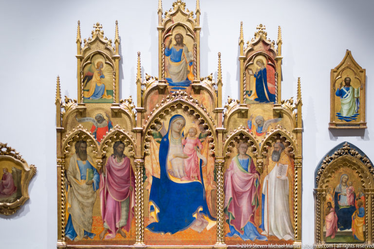 Elaborate gilded polyptych centered on the Virgin and Child in blue, with saints in tall pointed compartments.
