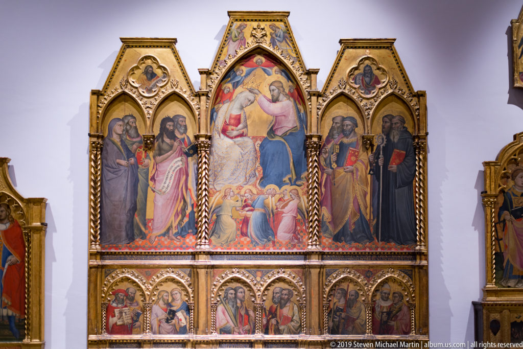 Gilded Gothic triptych with a central Virgin and Child scene, saints in side panels, and smaller scenes below.