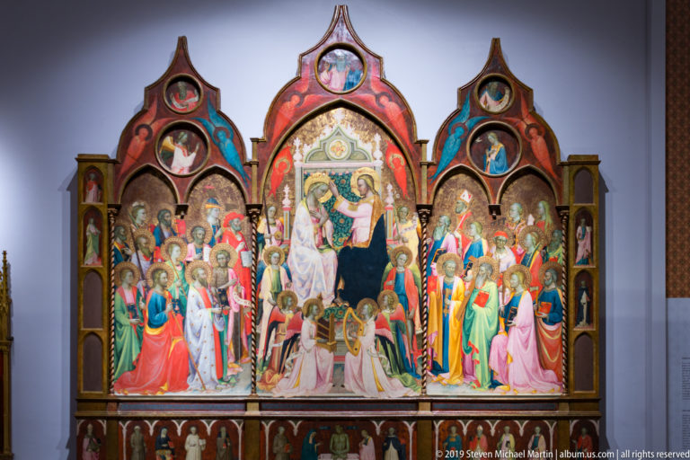 Large gilded Gothic polyptych with the Virgin and Child at center, surrounded by saints in pointed panels.