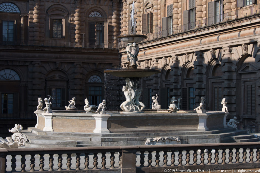 Tiered sculptural Artichoke Fountain before the heavily rusticated courtyard façades of Pitti Palace.