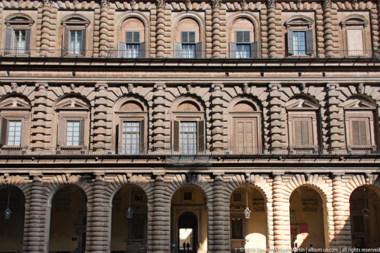 Rusticated stone exterior of Pitti Palace with repeated windows and strongly modeled masonry.