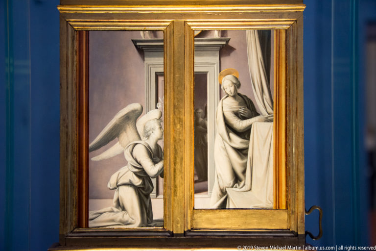Small hinged painting of the Annunciation, with a kneeling angel at left and the seated Virgin at right.