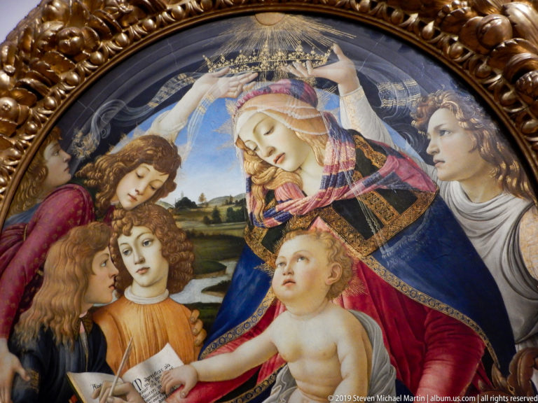 Detail of Botticelli’s Madonna of the Magnificat showing the crowned Virgin, Christ Child, angels, manuscript, and pomegranate.