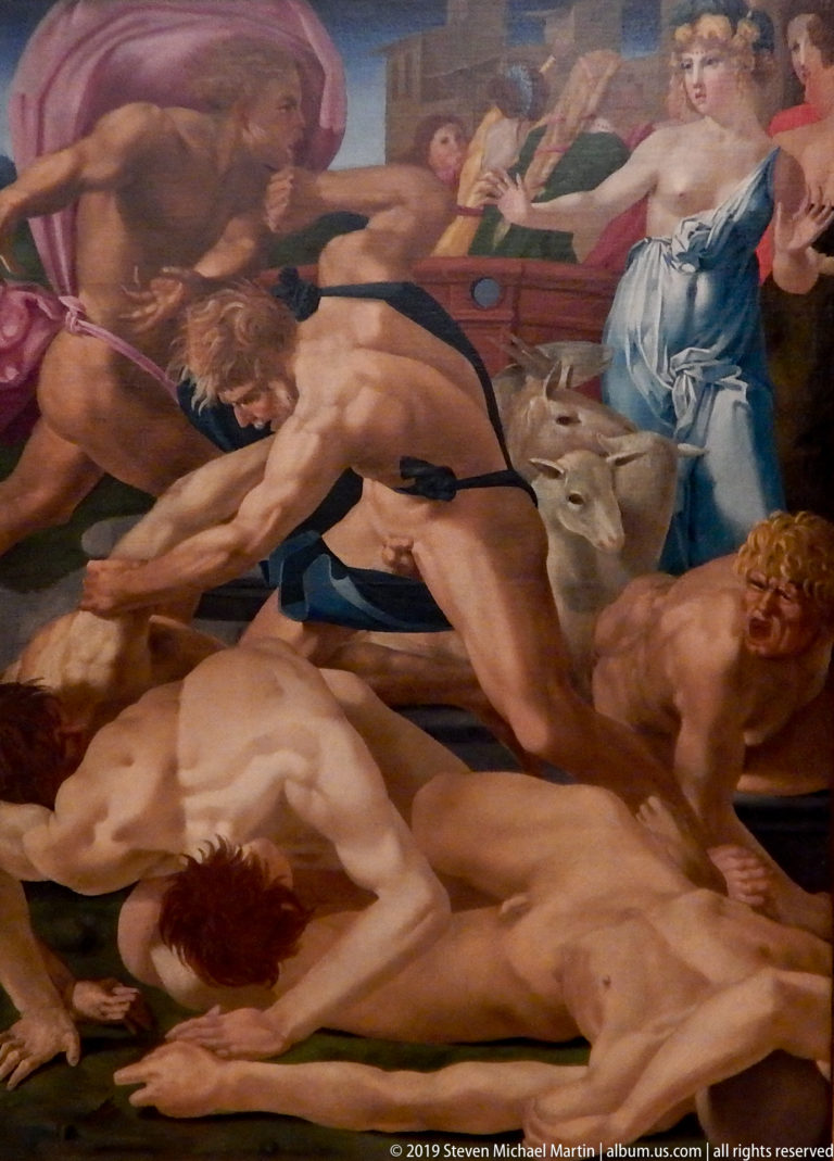Wide painted battle scene with muscular nude men struggling around fallen figures and an animal form.