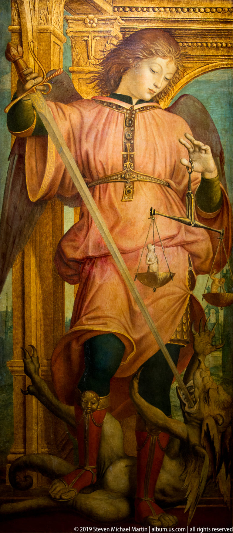 Seated woman in a salmon robe holding a long sword, with a balance scale beside her.