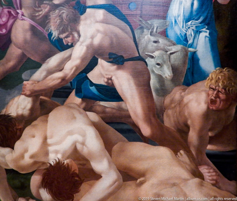 Muscular nude men struggle over fallen bodies in a tightly cropped painted battle scene.