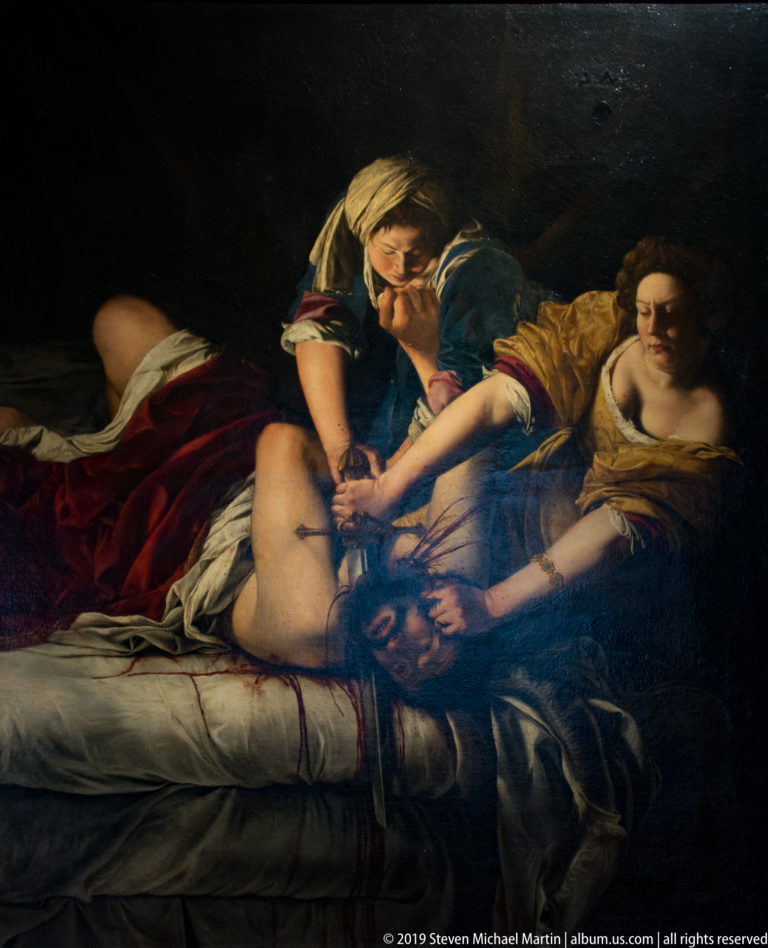 Artemisia Gentileschi’s Judith and her maidservant overpower Holofernes as Judith cuts his neck with a sword.
