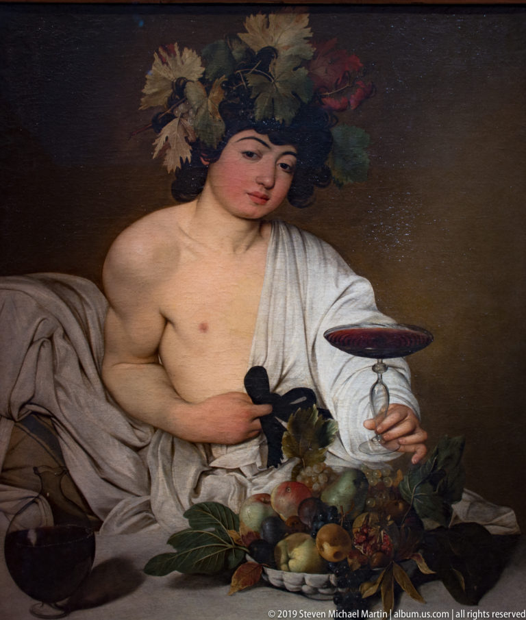 Caravaggio’s Bacchus, a vine-crowned youth offering red wine beside a basket of ripe fruit and classical drapery.