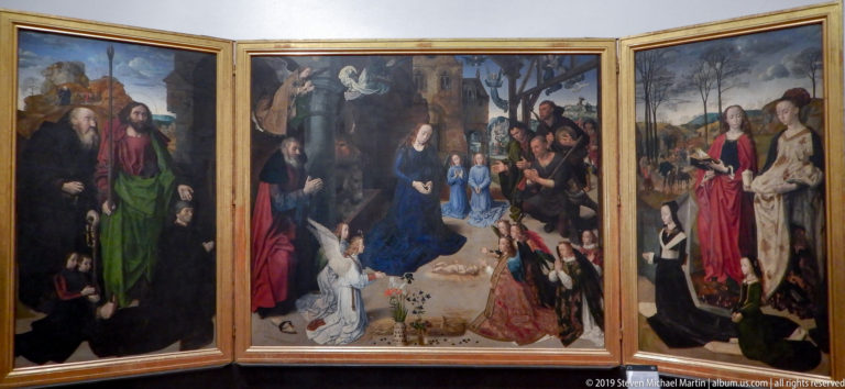 Open three-panel altarpiece with the Virgin and Child in the crowded center and sacred figures on the side wings.