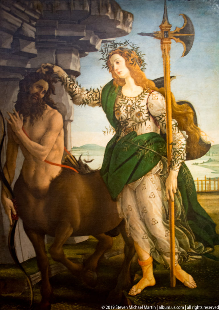 Botticelli’s armed Pallas grips a centaur by the hair while holding a battle axe in a rocky landscape.