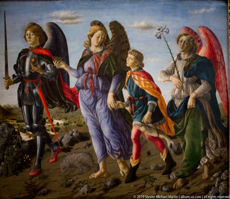 Young traveler walks through a rocky landscape with two winged angels and a small dog.