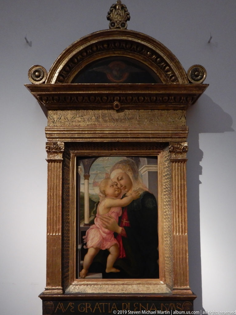 Botticelli’s Madonna della Loggia showing Mary and the embracing Christ Child within an open Renaissance architectural setting.