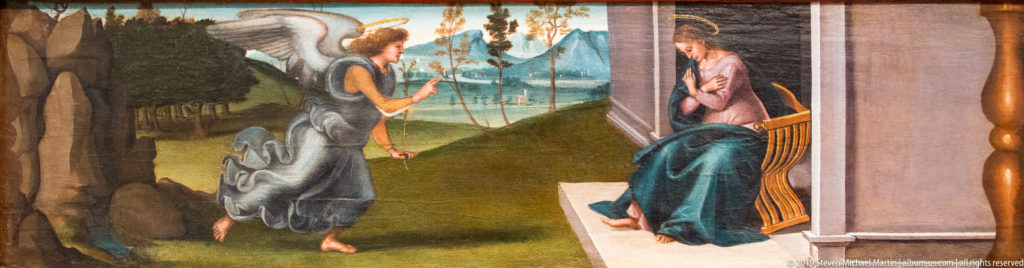 Winged angel approaches the seated Virgin beside a columned building, with a broad green landscape behind them.