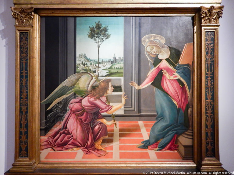 Botticelli’s Annunciation with Gabriel kneeling across a red-tiled Renaissance interior from the Virgin Mary.
