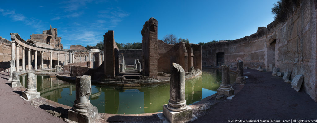 Wide view of the Maritime Theatre with foreground columns, circular pool, brick island walls, and curving enclosure.