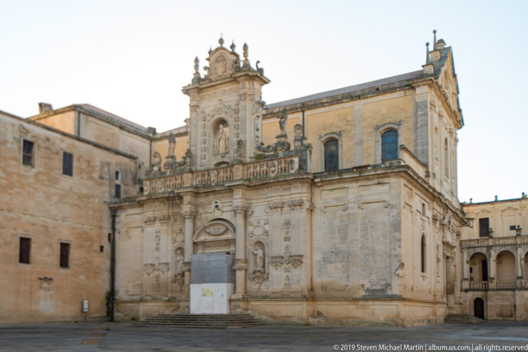Ornate side façade of Lecce Cathedral with pilasters, niches, balustrade and central doorway in Piazza del Duomo.