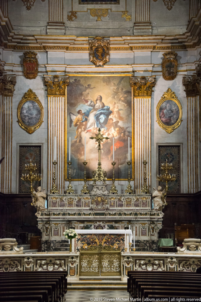 Frontal view of Gennaro De Martino’s 1757 high altar beneath Oronzo Tiso’s Assumption of Mary, with gilded pilasters and oval paintings.