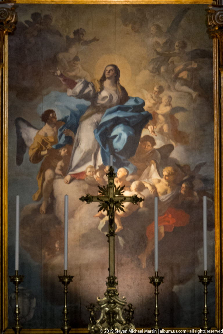 Oronzo Tiso’s 1757 Assumption of Mary above the high altar, with the Virgin rising among angels behind a crucifix and candles.