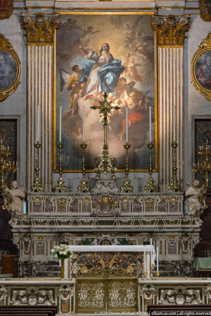 Polychrome marble high altar by Gennaro De Martino beneath Oronzo Tiso’s Assumption of Mary, framed by gilded pilasters and kneeling angels.