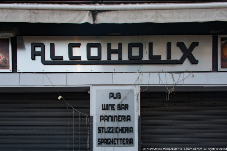 A storefront sign reads Alcoholix above panels advertising a pub, wine bar and food service.