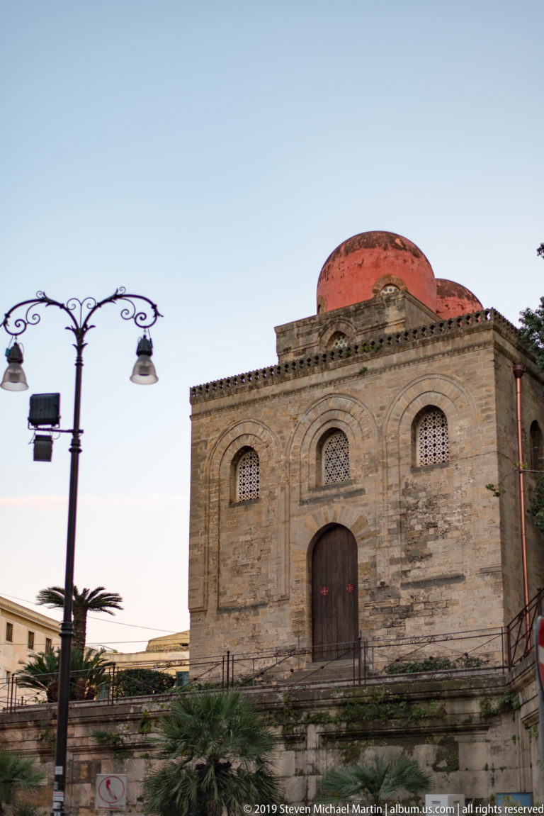 San Cataldo’s red dome and façade appear beyond a decorative streetlamp in Piazza Bellini.
