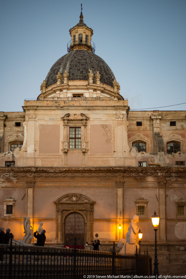 The pale façade and red dome of San Cataldo rise above its central doorway.