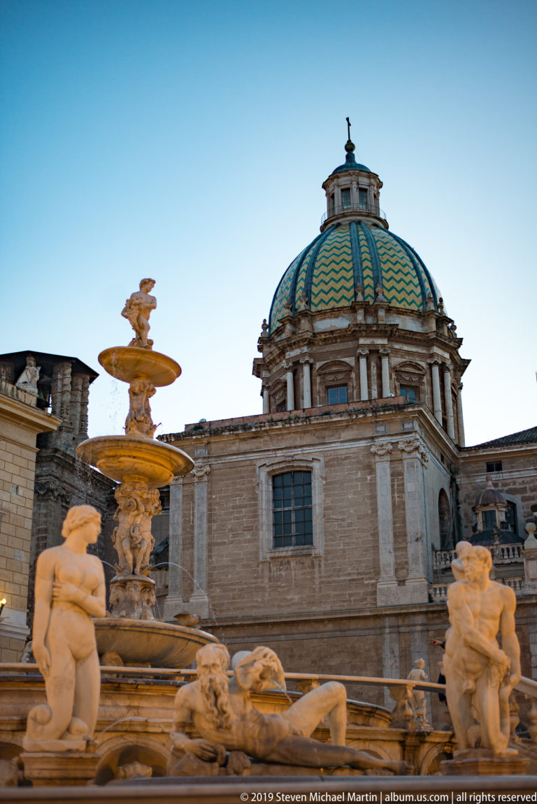 Fontana Pretoria fills the foreground, with the domed Church of San Cataldo behind the statues.