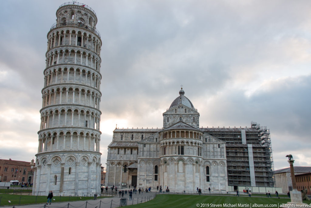 Leaning Tower at left with Pisa Cathedral and the domed Baptistery across the green Piazza dei Miracoli.