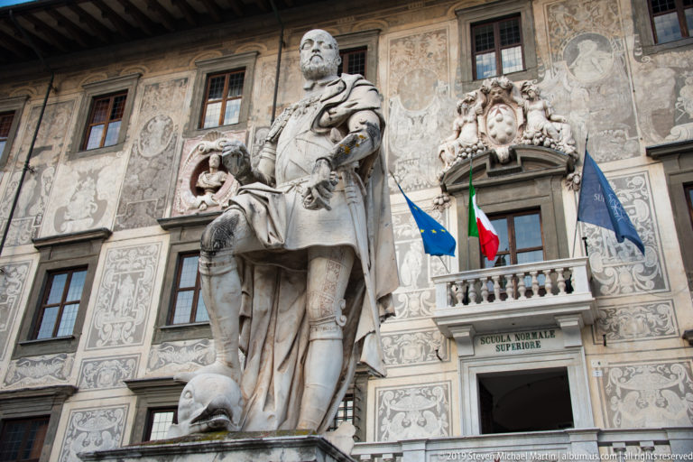 Statue of Cosimo I de’ Medici by Pietro Francavilla standing before Palazzo della Carovana in Piazza dei Cavalieri.