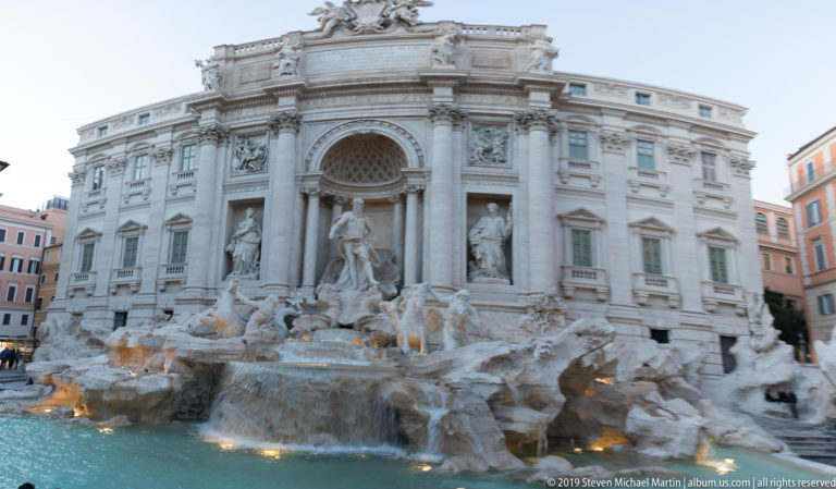 Trevi Fountain with monumental Baroque façade, central statuary, rocky cascades, and turquoise basin in Rome.
