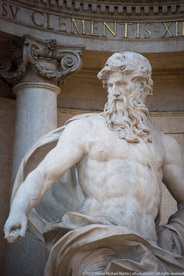 Marble figure of Oceanus with flowing beard and drapery seated in the central niche of the Trevi Fountain.
